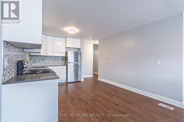 Kitchen area with stainless steel appliances, grey counters, and light grey walls. - A - 1132 The Queensway Avenue, Toronto