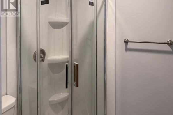 Corner shower stall with clear glass doors and chrome fixtures. - A - 23 Peter Street S, Orillia