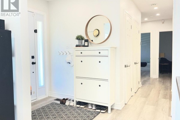 View down the hallway from the entrance, showing doors and light wood flooring. - A - 38 Wishing Well Drive, Toronto