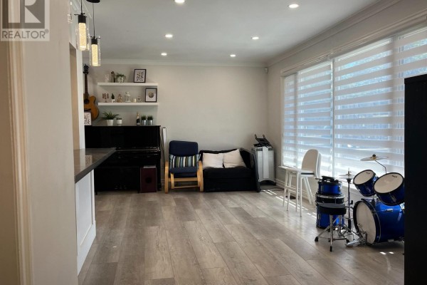 Open concept living and dining area with a bar, piano, sofa, and drum set visible. - A - 38 Wishing Well Drive, Toronto
