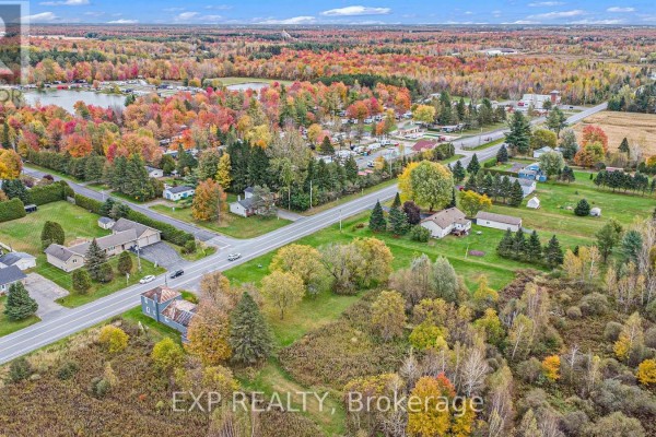 Wide view of the neighborhood featuring homes, trees, and a glimpse of a nearby water body. - A - 620 Limoges Road, The Nation