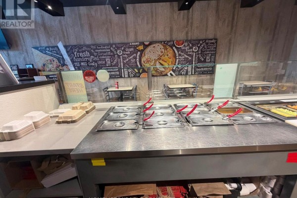 Commercial kitchen with stainless steel sink, cleaning supplies, and metal shelving. - A-11.5 - 2630 Simcoe Street N, Oshawa