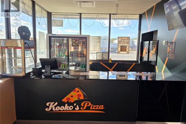 Counter with a refrigerated drink display and computer, overlooking a street view. - A 2740 Avonhurst Drive, Regina