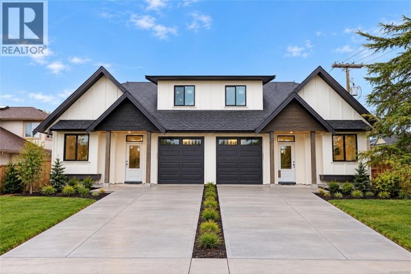 Front view of a modern duplex building with identical entrances and garage doors. - A 9650 Third St, Sidney