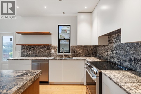 Kitchen with white cabinets, stainless steel appliances, and dark speckled granite countertops. - A 9650 Third St, Sidney