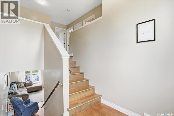 Interior staircase with wooden treads and white risers, adjacent to a living area view. - A-b 141 Queen Street, Elbow