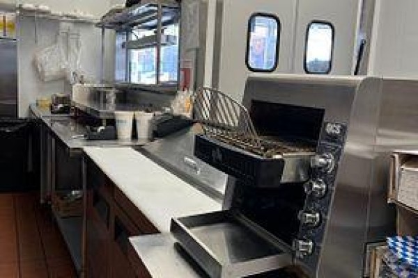 Food preparation area with fryer and countertop space in a commercial kitchen. - A010 - 4543 Kingston Road, Toronto