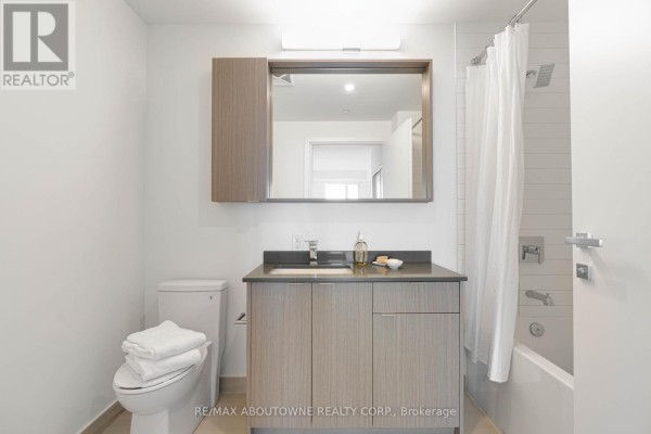 Bathroom with a single vanity, bathtub, toilet, and a mirrored cabinet. - A0815 - 125 Bronte Road, Oakville