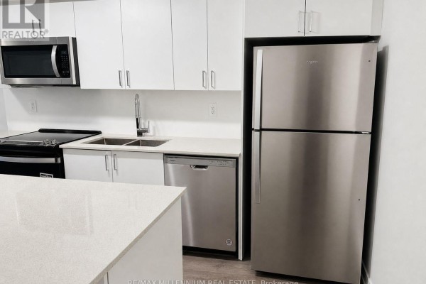 Modern kitchen with stainless steel appliances, white cabinetry, and quartz countertops. - A114 - 1650 Victoria Park Avenue, Toronto