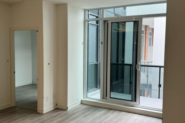 View of a sliding glass door opening to a balcony from a room with a large window. - A1405 - 8119 Birchmount Road N, Markham