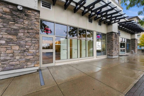 Ground-level storefront with large glass windows, double glass doors, and stone facade. - A145 20487 65 Avenue, Langley