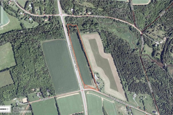 Aerial map displays multiple farmland parcels in a rural area, with one large property highlighted in turquoise along a highway. - Acreage Aa Macdonald Highway, Brudenell