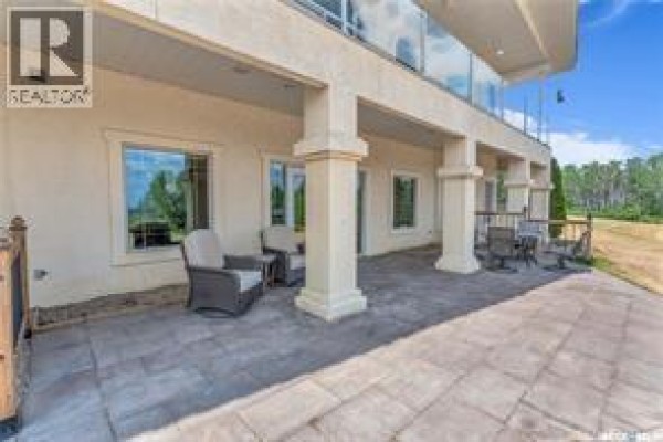 Covered patio area with seating and large windows on the side of a house. - Atcheynum Acreage, Battle River Rm No  438