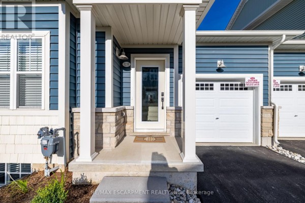 Front door of the townhouse with a glass panel, white trim, and a welcome mat. - B - 10 Shores Lane, Fort Erie
