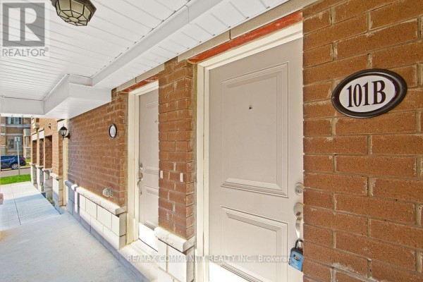 Close-up of brick exterior with two beige doors, one labeled 101B, under a white overhang. - B - 101 Luzon Avenue, Markham