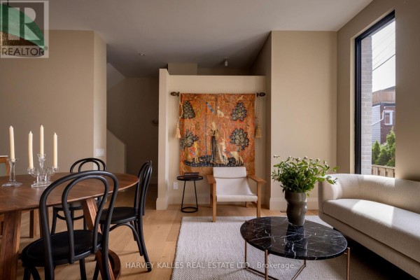 Living and dining area with a sofa, coffee table, and tapestry on the wall. - B - 157 Hallam Street, Toronto