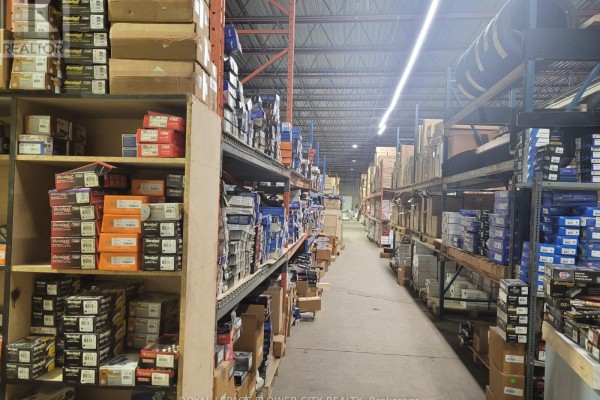 Commercial building side view showing a large bay door and loading dock area. - B - 2395 Lucknow Drive, Mississauga