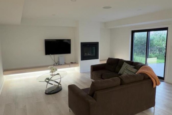 Empty living space with large windows, black frames, and a granite countertop kitchen island. - B - 2573 Bridgehaven Drive, London North