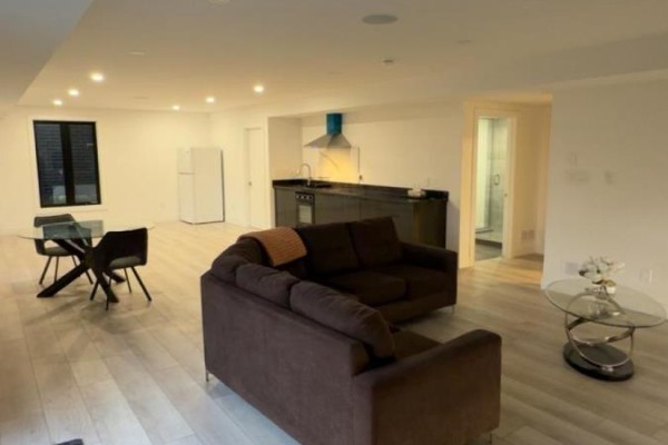 Open concept basement with a modern kitchen, dark cabinets, stainless steel hood fan, and dining table. - B - 2573 Bridgehaven Drive, London North