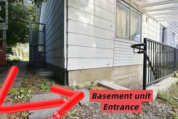 Finished basement with light beige walls, wood-look flooring, and a small white table. - B - 3420 Albion Road S, Ottawa