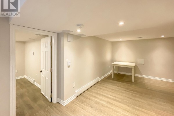 Basement kitchen with white and dark wood cabinets, stainless steel appliances, and a tiled backsplash. - B - 3420 Albion Road S, Ottawa