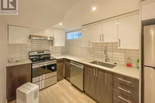 Bathroom with a white vanity, large mirror, toilet, and bathtub with a tiled wall. - B - 3420 Albion Road S, Ottawa