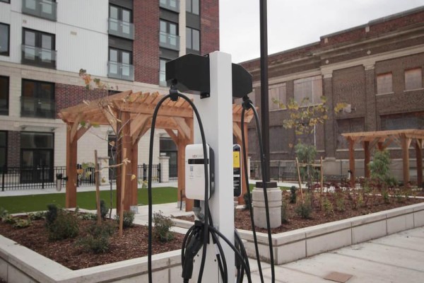 Close-up of an electric vehicle charging station in the courtyard with surrounding greenery. - B - 370 South Street S, London East