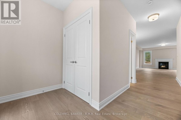 Interior hallway with beige walls, hardwood floors, and double doors. - B - 434 Orchard Avenue S, Cobourg