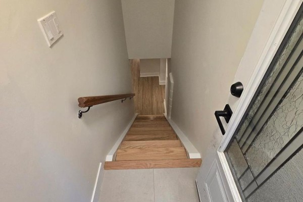 Wooden staircase with a handrail descending from the front entrance into a hallway. - B - 50 Elmer Avenue, Orillia