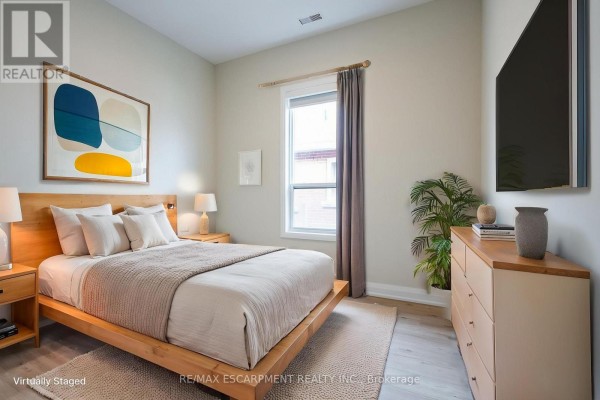 Bedroom with wooden bed frame, dresser, and abstract art on the wall. - B - 728 Eleventh Avenue, Hamilton