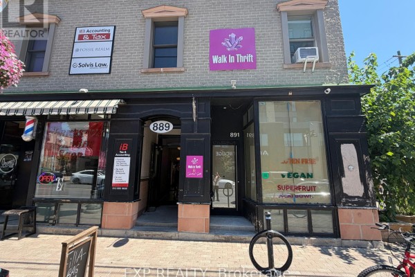 Facade of a commercial building with signage for various businesses, including accounting and thrift stores. - B - 889 Bank Street, Ottawa