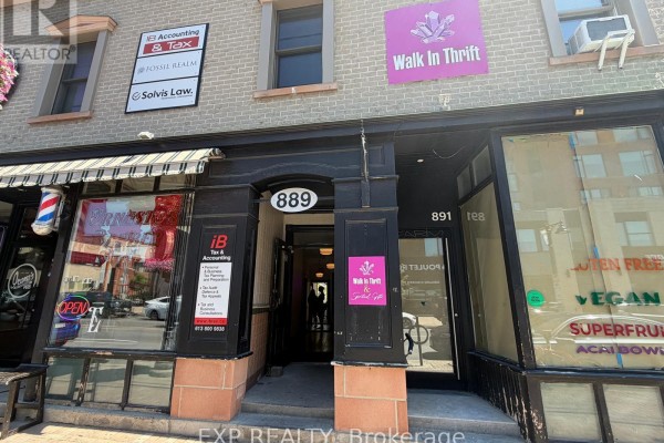 Entrance to 889 Bank Street commercial building with adjacent storefronts and signage. - B - 889 Bank Street, Ottawa