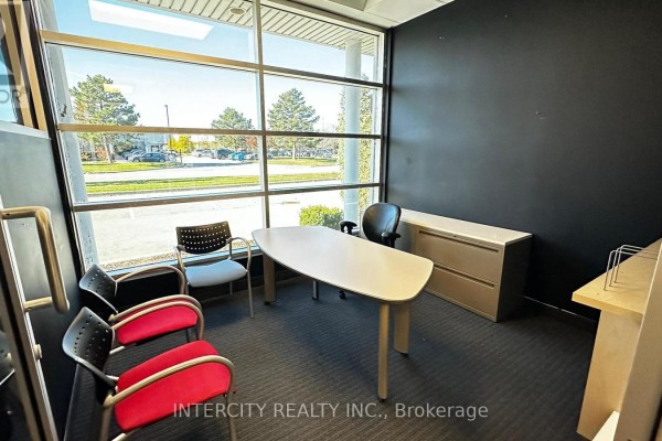 A small office room with a light-colored desk, black office chair, filing cabinet, and large window. - B - 99 Sante Drive, Vaughan