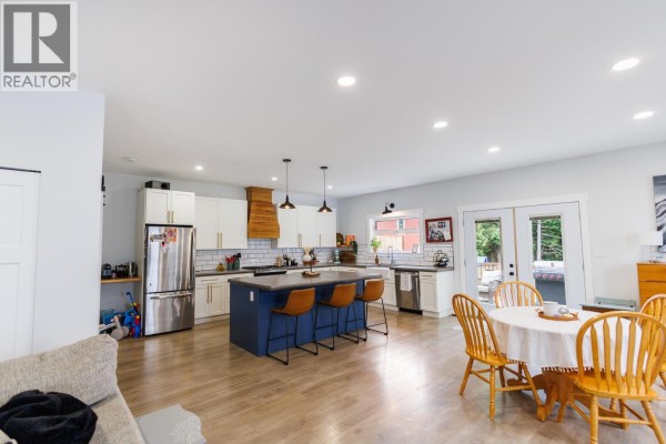 Wide view of the open-concept kitchen and dining area with a large island and dining table. - B 4005 Benner Street, Terrace