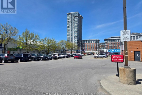 View of a busy parking lot with a Wendy's drive-thru sign and tall buildings. - B10 - 4779 Steeles Avenue E, Toronto
