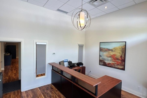 View of the reception area showing the desk, artwork, entrance, and a hallway. - B108 - 11685 Yonge Street, Richmond Hill