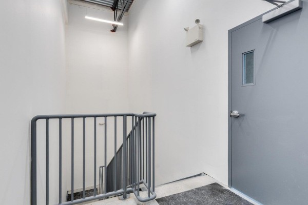 Grey metal staircase and door with window, next to white wall and fire extinguisher. - B14 8650 Dewdney Trunk Road, Mission