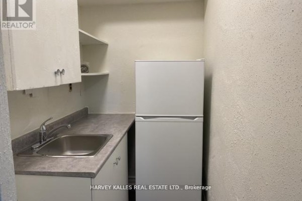 Bathroom with a white bathtub, a vanity sink, and marble-patterned wall tiles. - B2 - 1582 Bathurst Street, Toronto