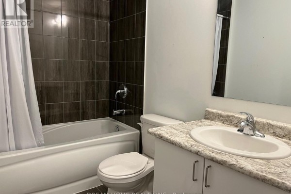 Bathroom with a bathtub, toilet, and vanity with a granite countertop. - B2 - 3 Falaise Road, Toronto