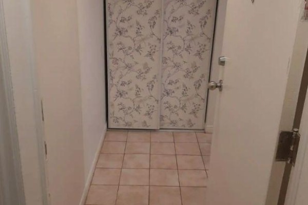 Interior hallway with beige walls and tiled floor leading to double doors. - B2 - 34 Penhurst Avenue, Toronto