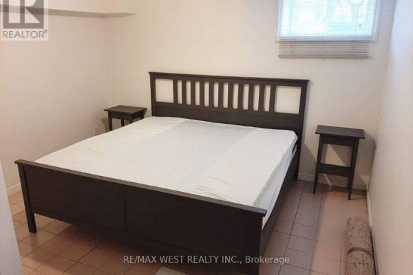 Bedroom with a king-size bed, dark wood frame, and two side tables. - B2 - 34 Penhurst Avenue, Toronto
