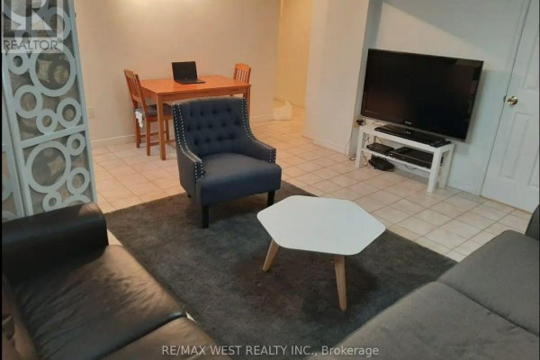 Living room with sectional sofa, armchair, coffee table, and television. - B2 - 34 Penhurst Avenue, Toronto