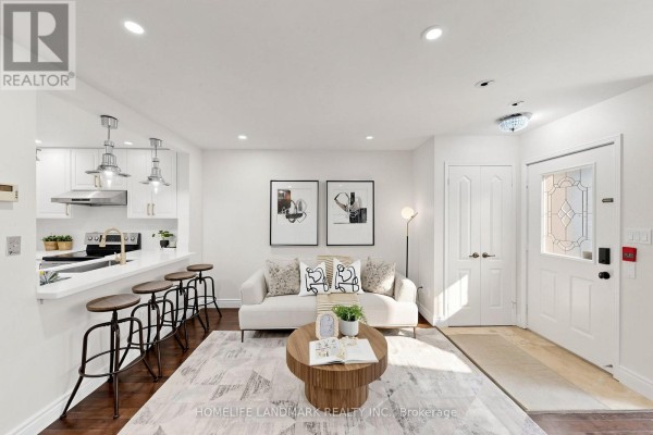 Living room with a white sofa, coffee table, and open-concept kitchen. - B29 - 108 Finch Avenue W, Toronto