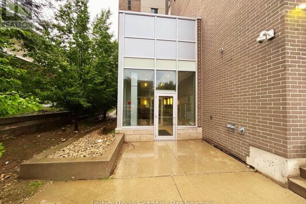 View from a balcony overlooking street with trees and modern building across. - B303 - 62 Balsam Street, Waterloo