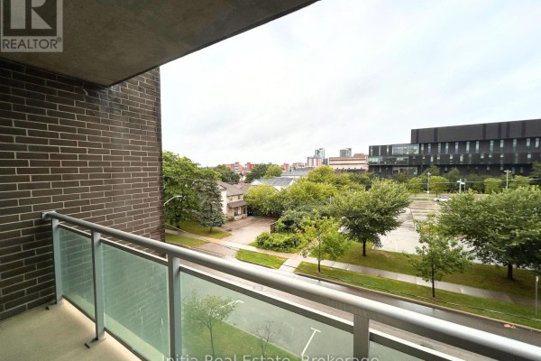 Overcast view of city street with trees and a large, dark modern building. - B303 - 62 Balsam Street, Waterloo