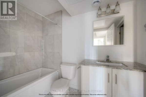 Bathroom with a white tub, toilet, vanity with granite countertop, and tiled walls. - B5 - 374 Prospect Avenue, Kitchener