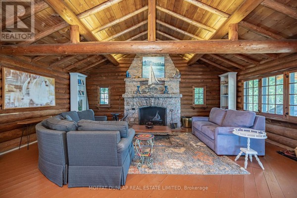 Living room with a stone fireplace, log walls, vaulted ceiling, and comfortable seating. - B691 Island Island, The Archipelago