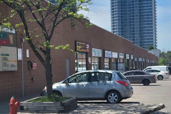 Brick commercial building exterior with parking lot and cars. - B8 - 2370 Midland Avenue, Toronto