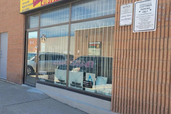 Storefront window with bars and signage, viewed from the sidewalk. - B8 - 2370 Midland Avenue, Toronto