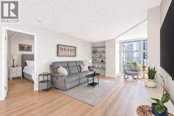 Living room with gray sofa, view of kitchen and dining area with white chairs and glass table. - B901 1331 Homer Street, Vancouver